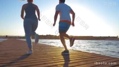 慢动作斯坦尼康和低角度拍摄的男人和女人在海岸度假村的木制码头上奔跑在日落